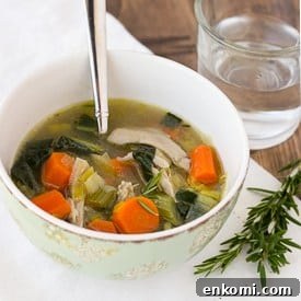 chicken soup in bowl with spoon and glass of water