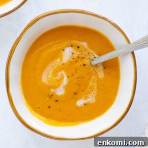 roasted sweet potato soup in a white bowl with a spoon