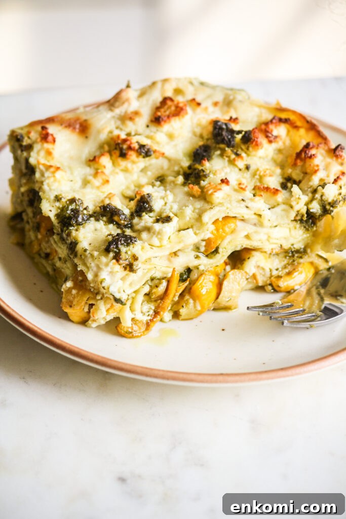 Roasted zucchini and pesto lasagna layered with cream cheese sauce and topped with feta