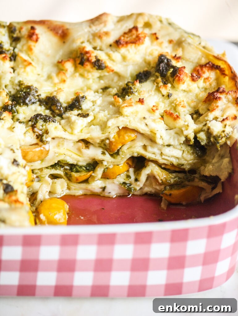 Roasted zucchini and pesto lasagna layered with cream cheese sauce and topped with feta