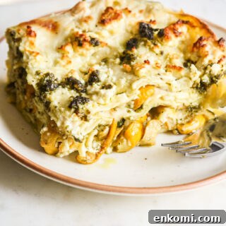 Roasted zucchini and pesto lasagna layered with cream cheese sauce and topped with feta