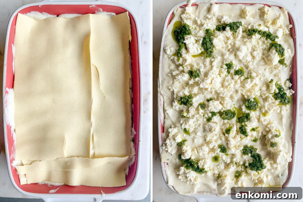 Roasted zucchini and pesto lasagna layered with cream cheese sauce and topped with feta