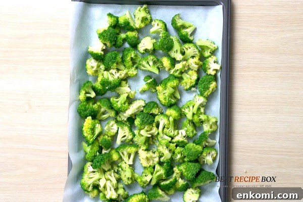 Raw broccoli pieces on a baking sheet pan