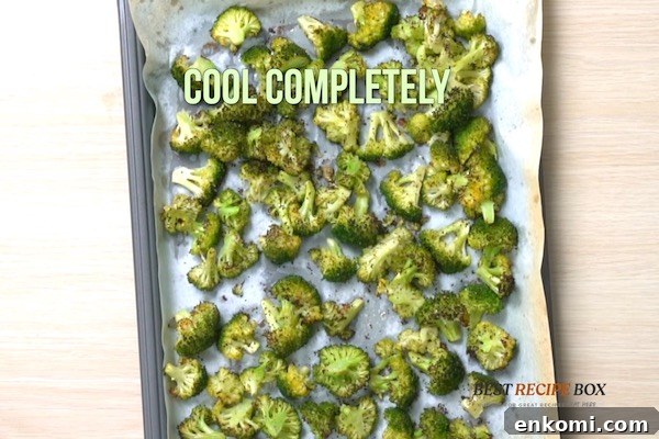 Cooked broccoli pieces on a baking sheet pan