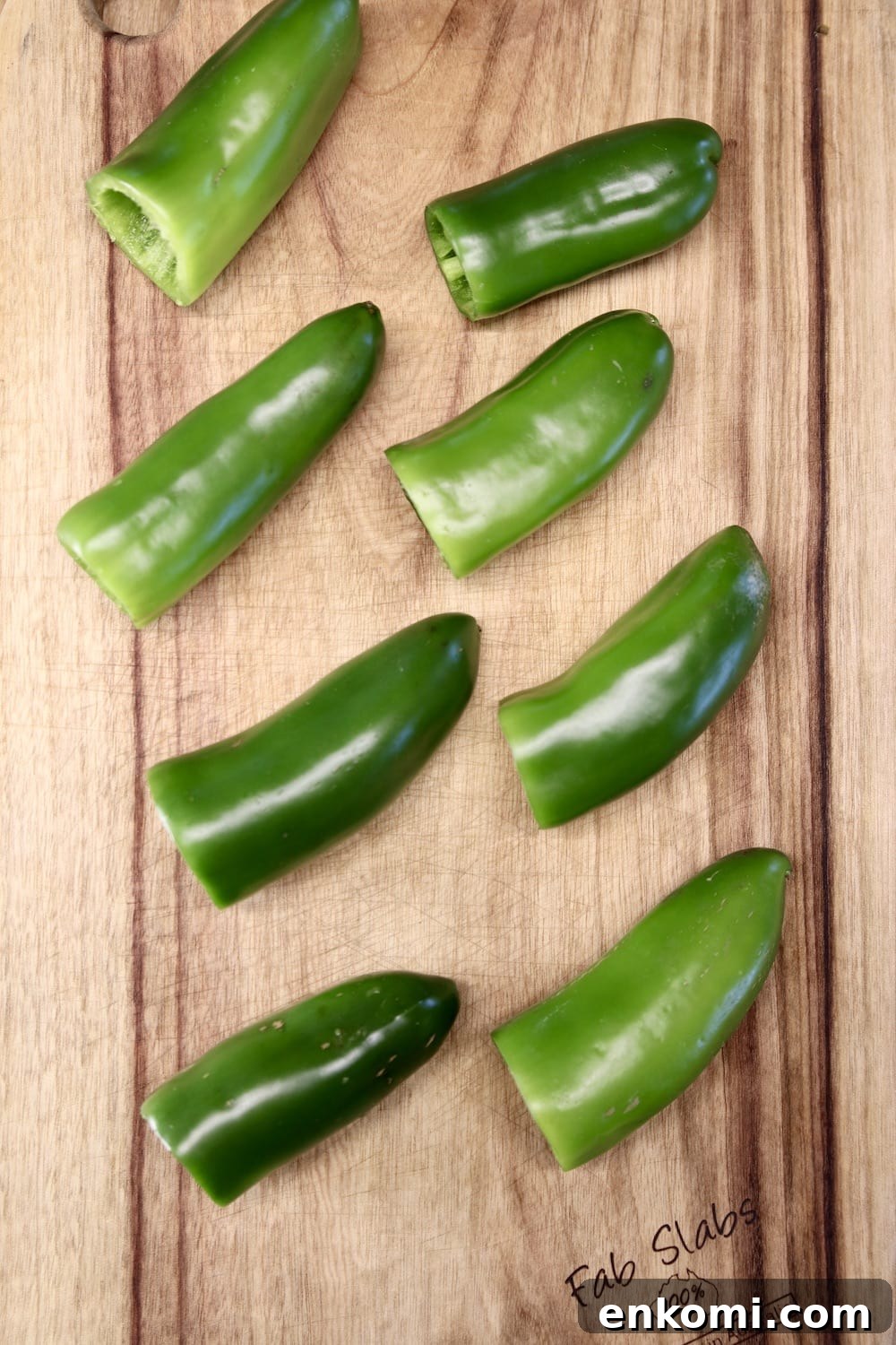 jalapeños with stems removed on a cutting board