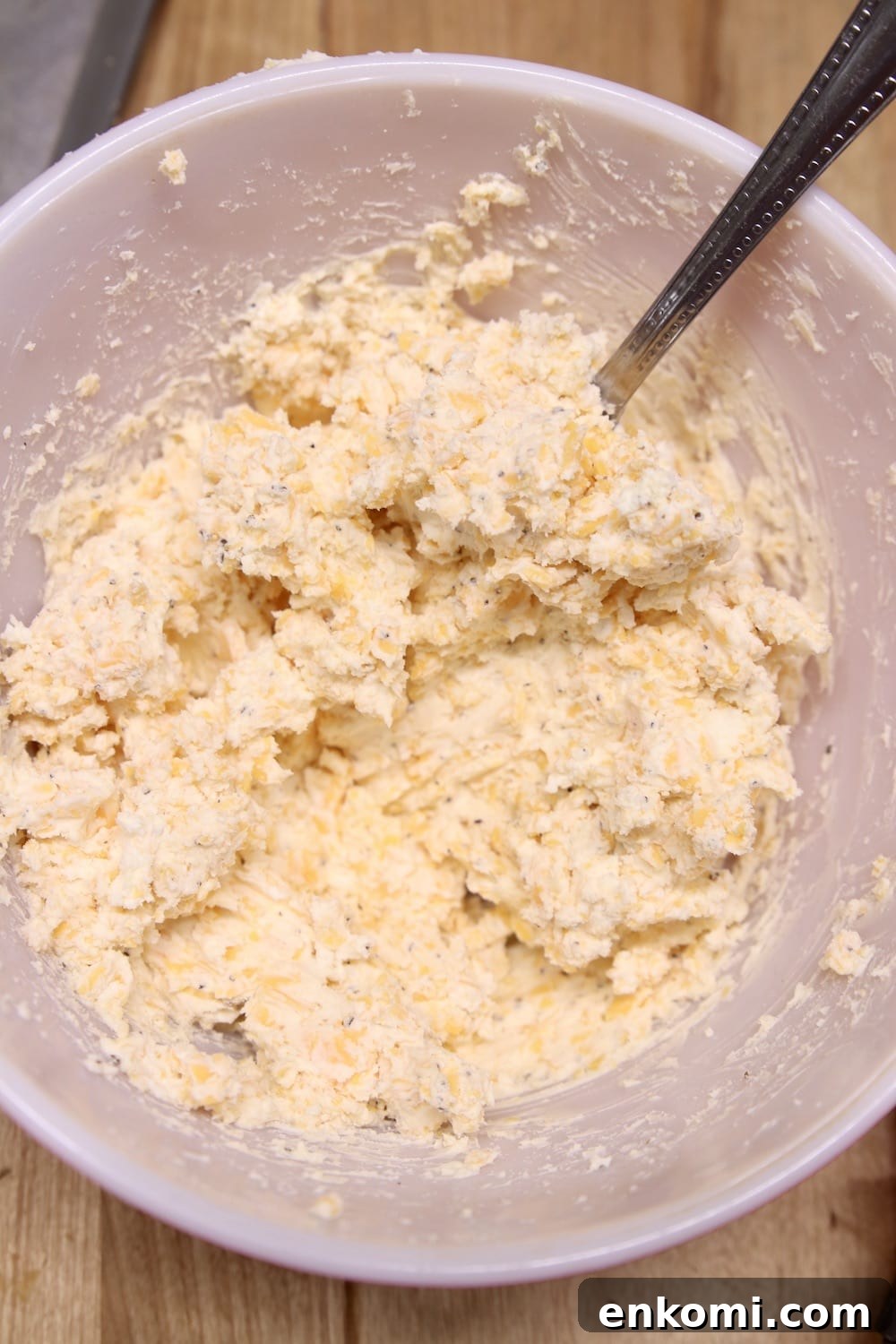 cream cheese with cheddar cheese filling mixed in a bowl with a spoon
