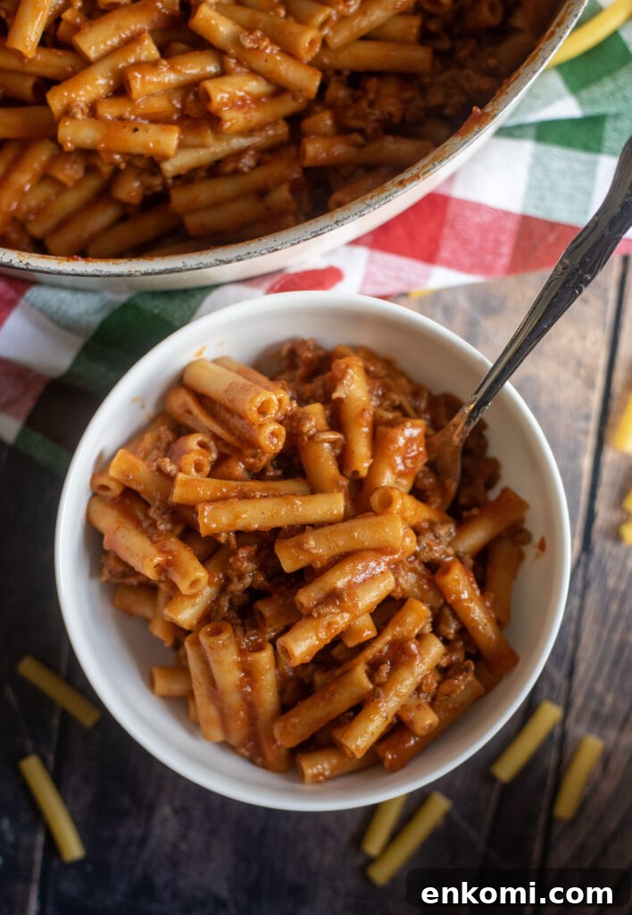 Finished homemade beefaroni in a bowl with creamy tomato sauce and ziti pasta, sprinkled with pepper