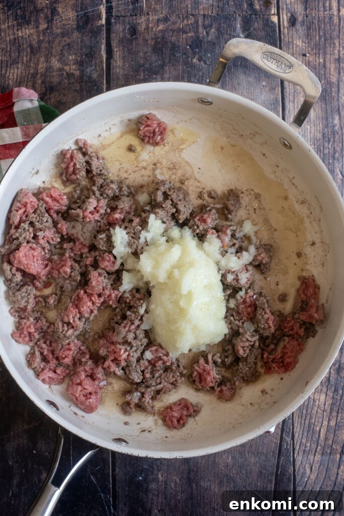 Browning 1 lb ground beef and 1 minced onion together in a skillet for homemade beefaroni