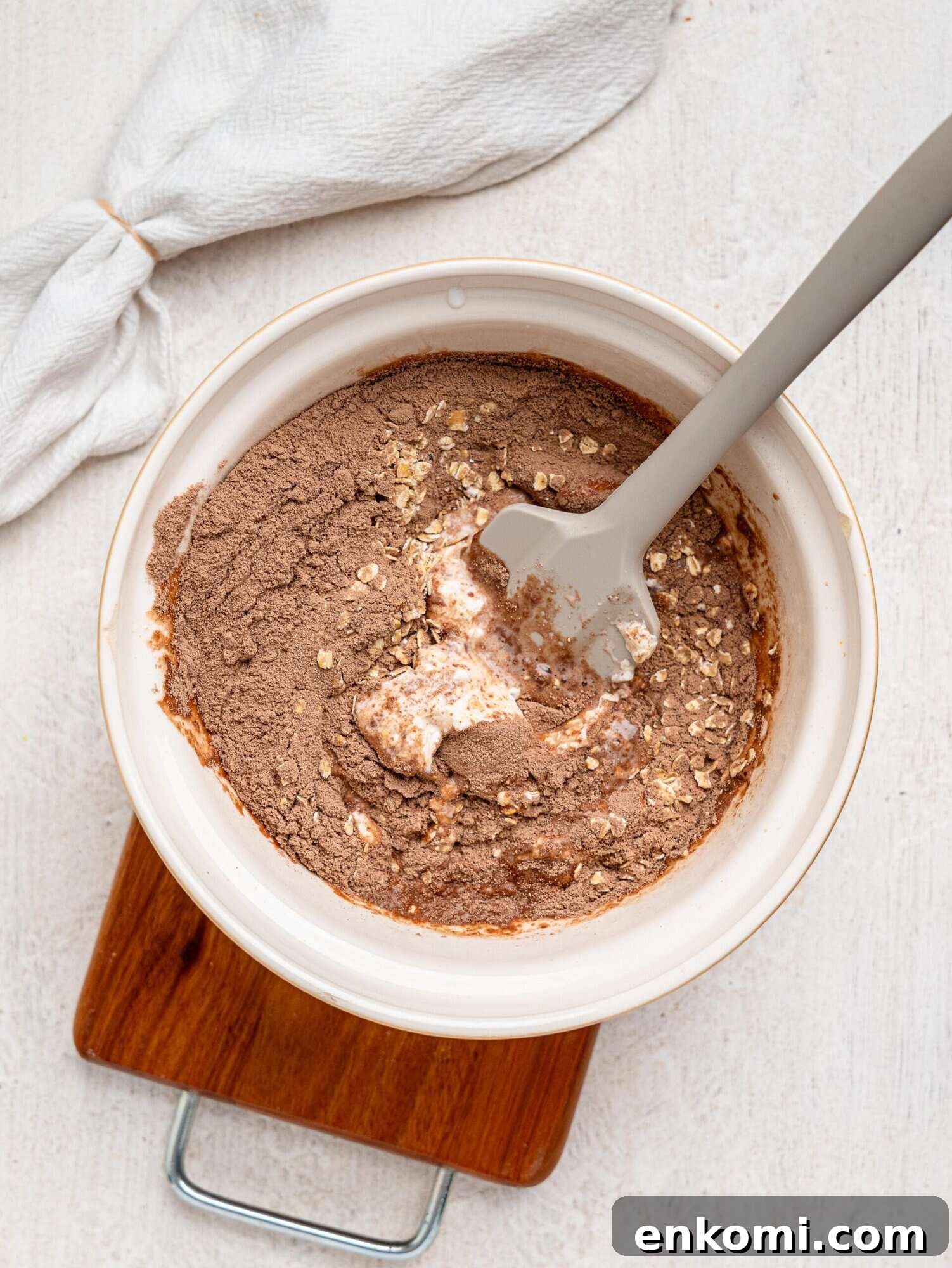 Creamy chocolate protein overnight oats ingredients in a mixing bowl.