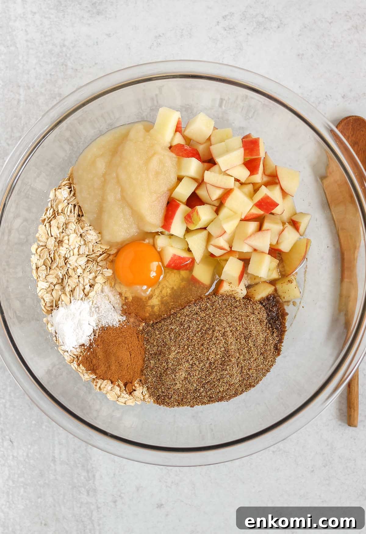 Warm Apple Cinnamon Baked Oatmeal with Crunchy Topping 4 Ingredients for apple cinnamon baked oatmeal in a large glass mixing bowl before being mixed.