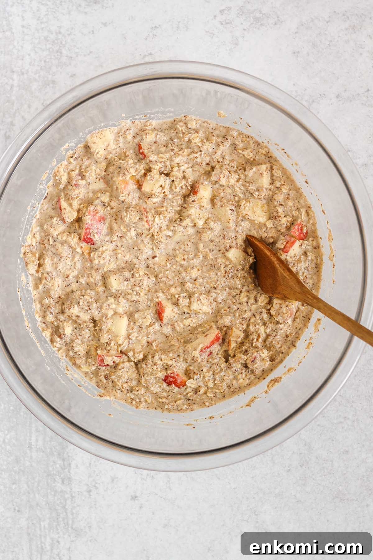 Warm Apple Cinnamon Baked Oatmeal with Crunchy Topping 5 Oatmeal mix with apples in a large glass mixing bowl.
