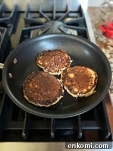 Three cottage cheese pancakes flipped over in a small fry pan.