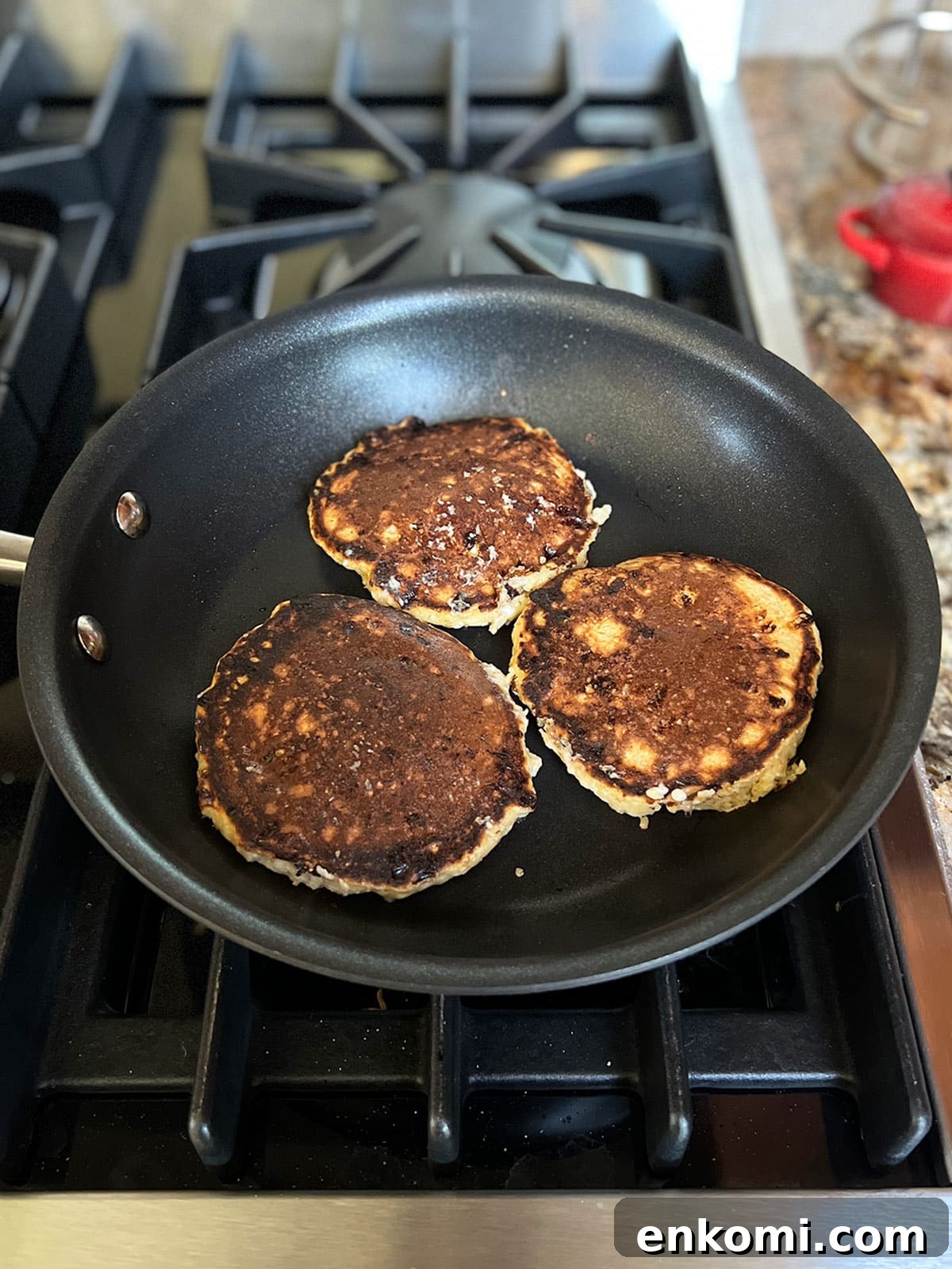 Three cheese latkes turned over in pan and almost finished cooking.