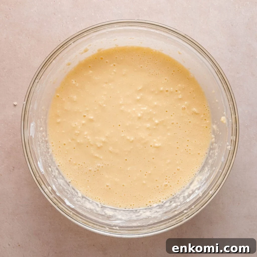 Butter, sugar, eggs, sour cream, kefir, and vanilla extract mixed in a bowl.