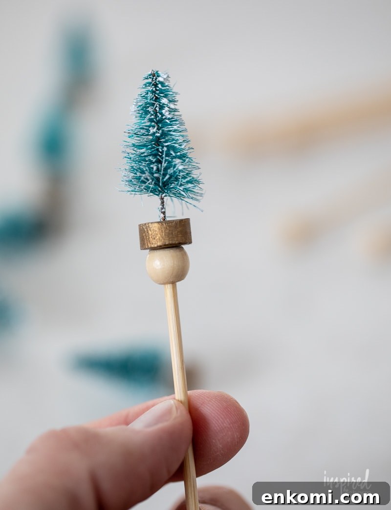hand holding Bottle Brush Tree Drink Stirrer.