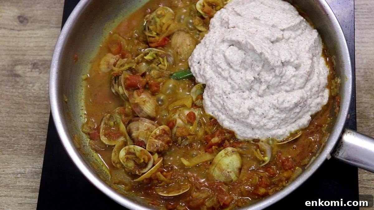 Authentic Goan Clam Curry Recipe 11 Adding ground coconut paste to clam curry.