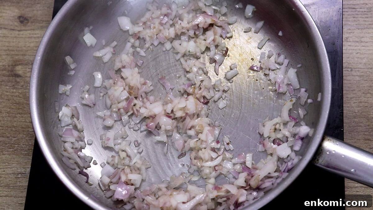 Authentic Goan Clam Curry Recipe 7 Sautéing chopped onion in a pan.