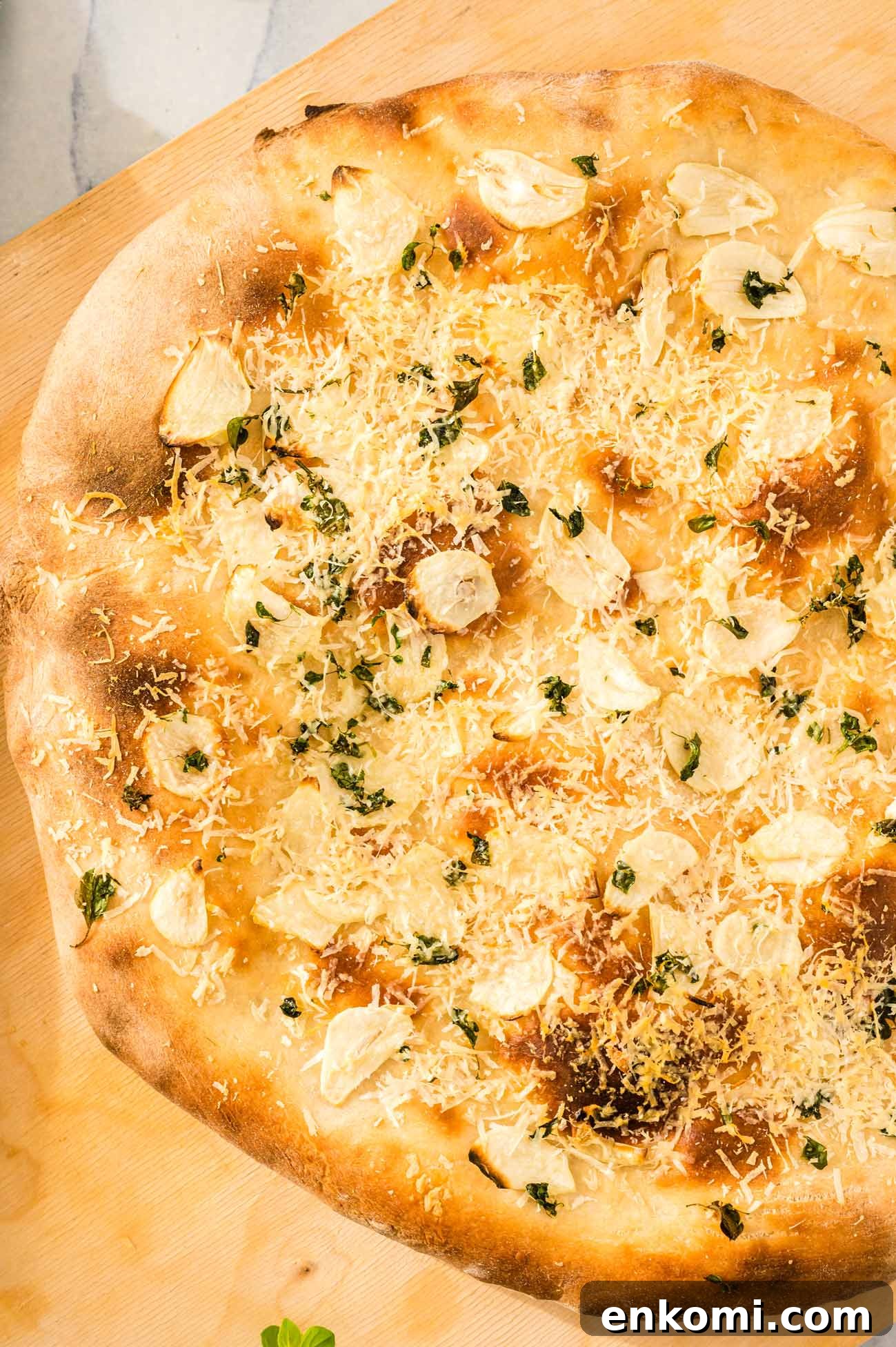 Garlic Lover's Pizza with Homemade Crust Recipe 3 A freshly baked garlic pizza on a cutting board.