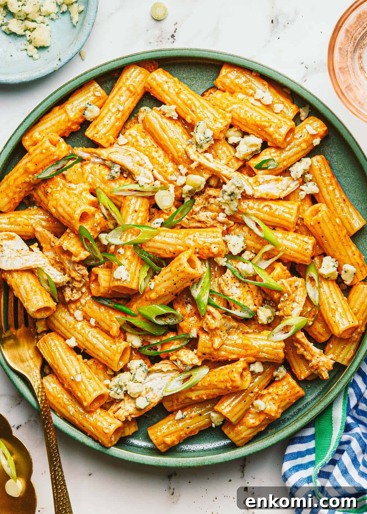 One-Pot Creamy Buffalo Chicken Pasta 2 Plate of buffalo chicken pasta garnished with blue cheese and green onion.