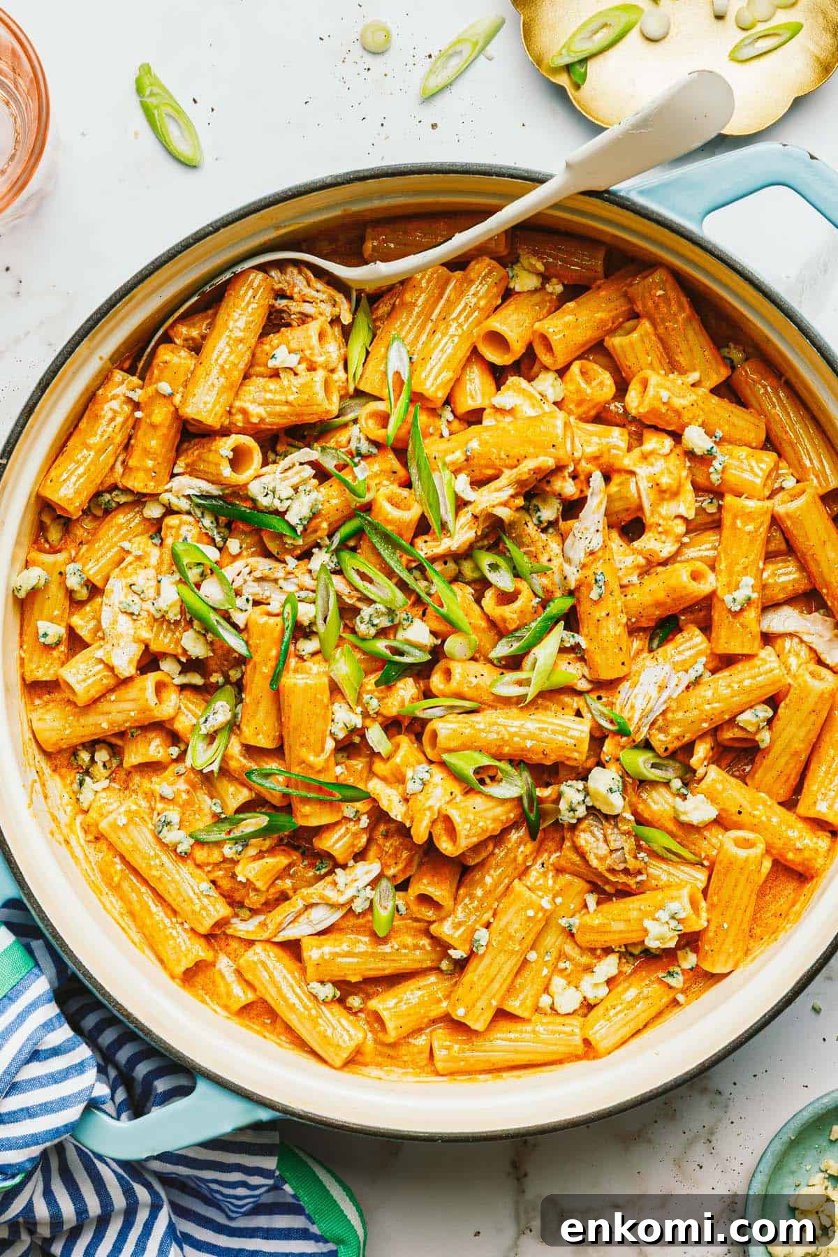 One-Pot Creamy Buffalo Chicken Pasta 7 Large pan of creamy buffalo chicken pasta garnished with blue cheese and green onion.