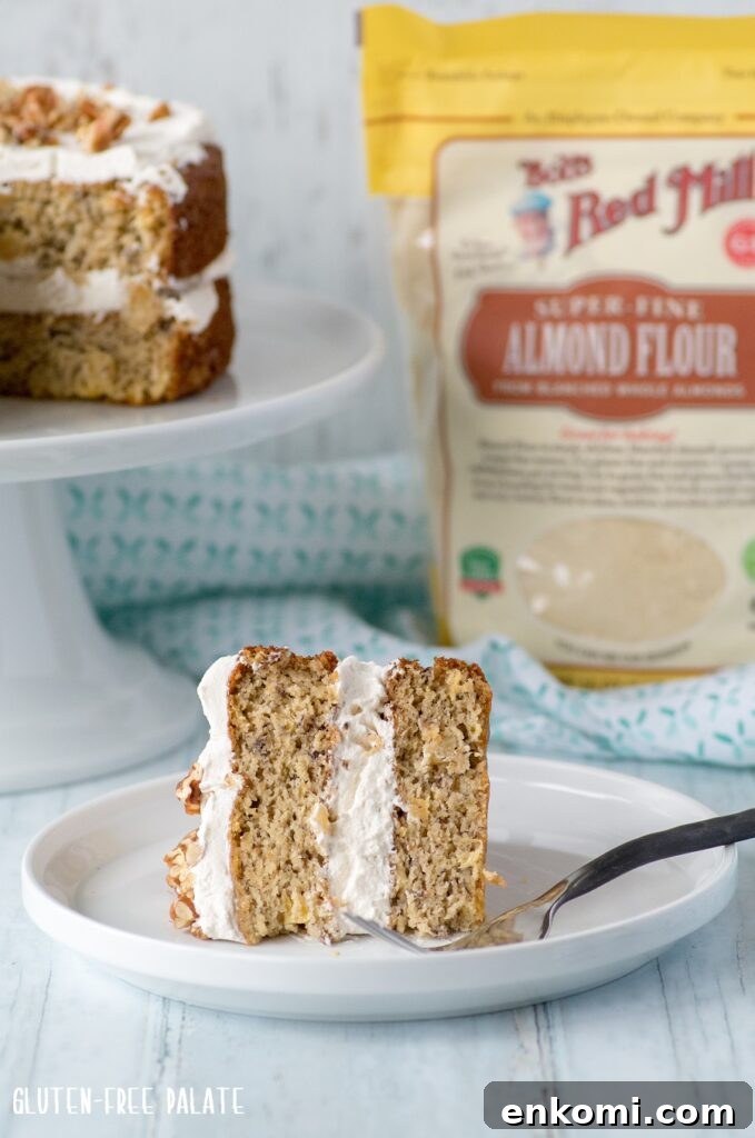 Gluten-Free Hummingbird Cake Recipe with Cream Cheese Frosting 3 a slice of gluten-free hummingbird cake on a white plate with a fork