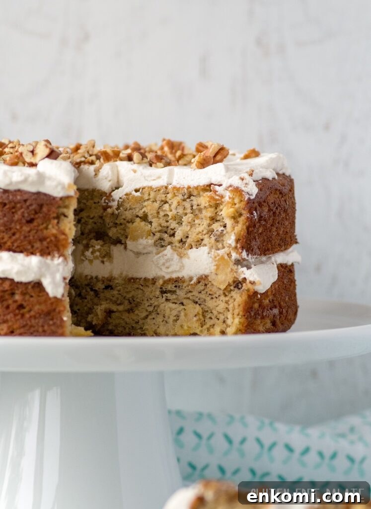 Gluten-Free Hummingbird Cake Recipe with Cream Cheese Frosting 5 a side view of a double layer hummingbird cake with a slice out showing the inside texture