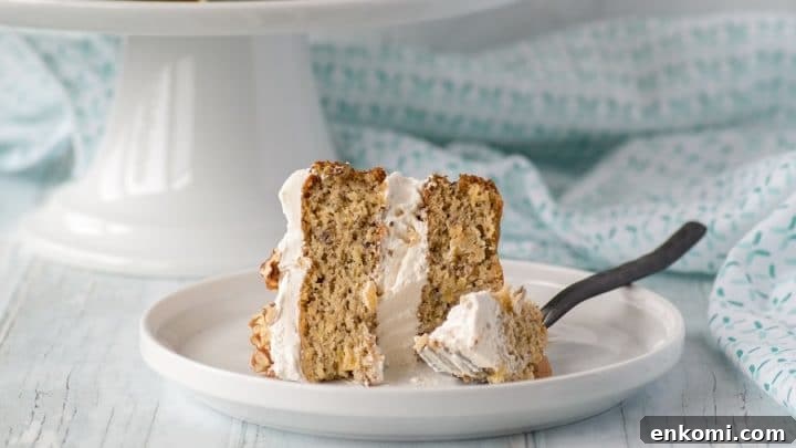 a close up of a slice of gluten-free hummingbird cake on a white plate with a fork