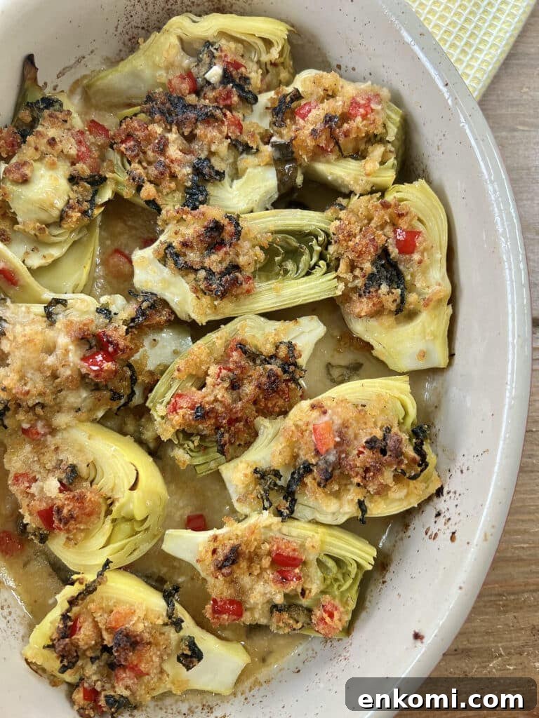 Oven-Roasted Italian Artichoke Hearts with Lemon Breadcrumbs 2 Finished, baked italian artichoke hearts oreganata in oval baking dish on yellow towel.