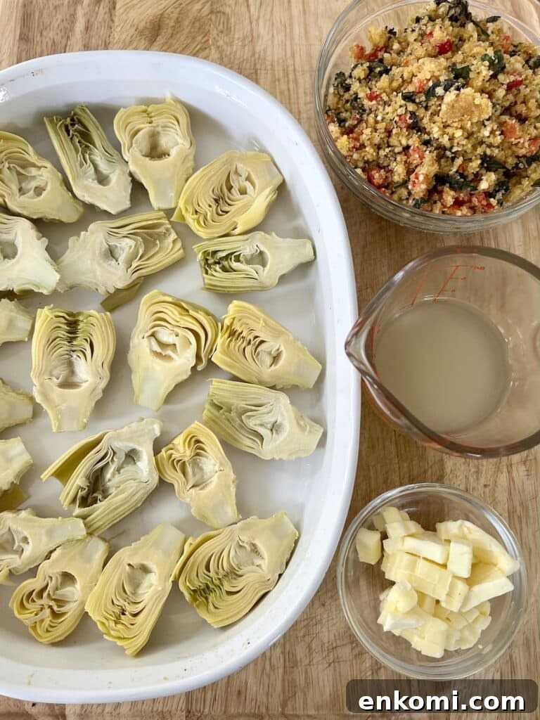 Oven-Roasted Italian Artichoke Hearts with Lemon Breadcrumbs 11 Prepped artichoke hearts in baking dish next to bowls of lemon breadcrumbs, white wine/lemon juice mixture and cubes of butter.