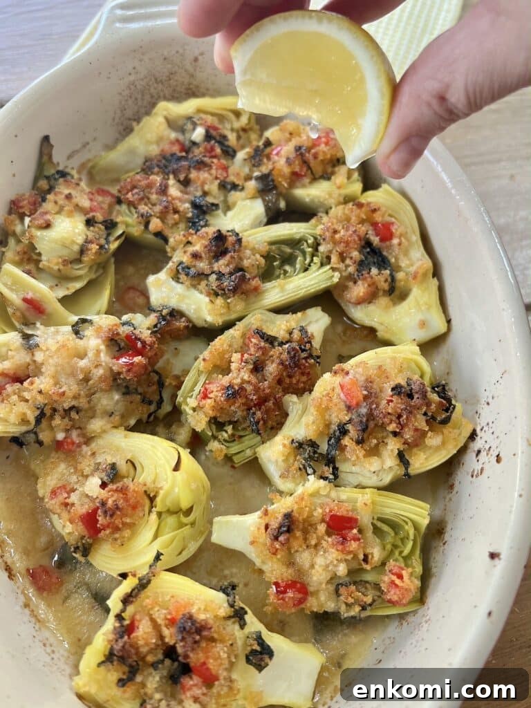 Oven-Roasted Italian Artichoke Hearts with Lemon Breadcrumbs 3 Squeezing lemon wedge over baked artichoke hearts, Italian-style.