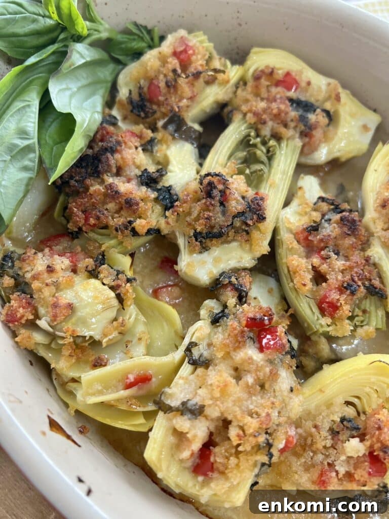 Oven-Roasted Italian Artichoke Hearts with Lemon Breadcrumbs 4 Roasted Italian artichoke hearts oreganata with lemon basil breadcrumbs in baking dish with basil garnish.