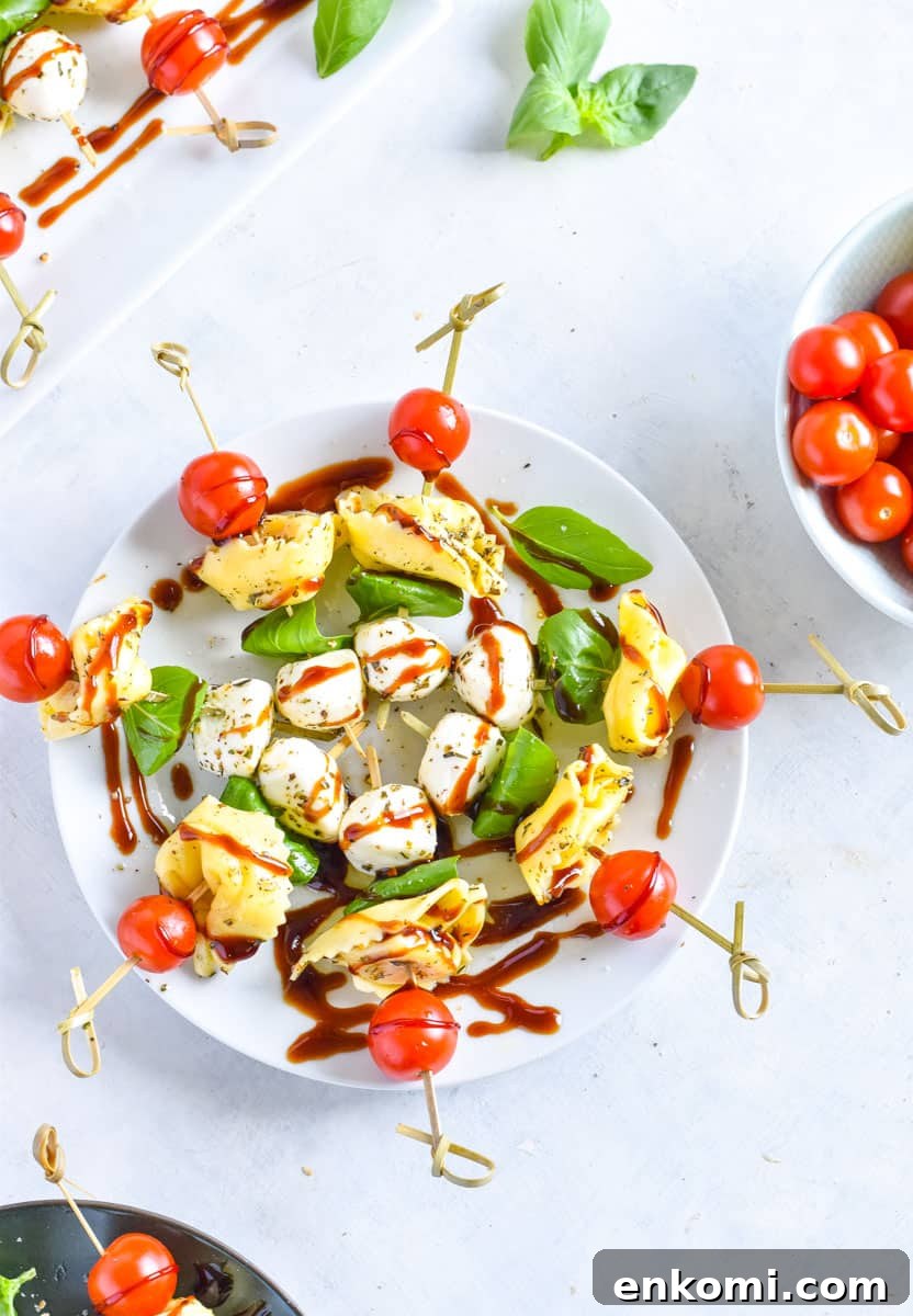 Caprese Tortellini Skewers with Cherry Tomatoes and Basil 2 Tortellini caprese skewers on a white plate