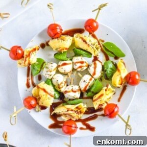 Caprese Tortellini Skewers with Cherry Tomatoes and Basil 8 Caprese skewers on white plate