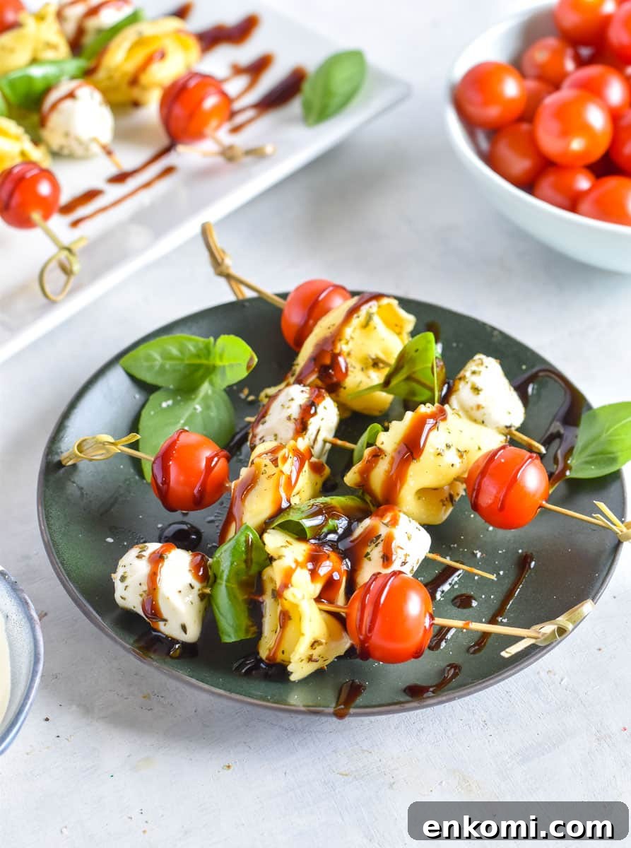 Caprese Tortellini Skewers with Cherry Tomatoes and Basil 7 Tortellini skewers on a green plate