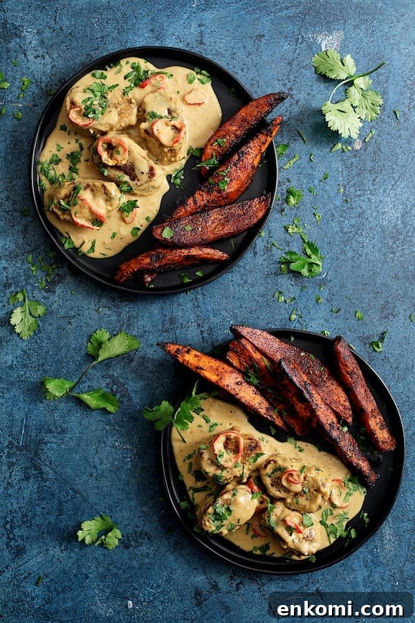 Spicy Tahini Pork Medallions with Harissa Sweet Potato Wedges 11 Photo of Spicy Tahini Pork Medallions with Harissa Roasted Sweet Potato Wedges on blue background garnished with cilantro sprigs.