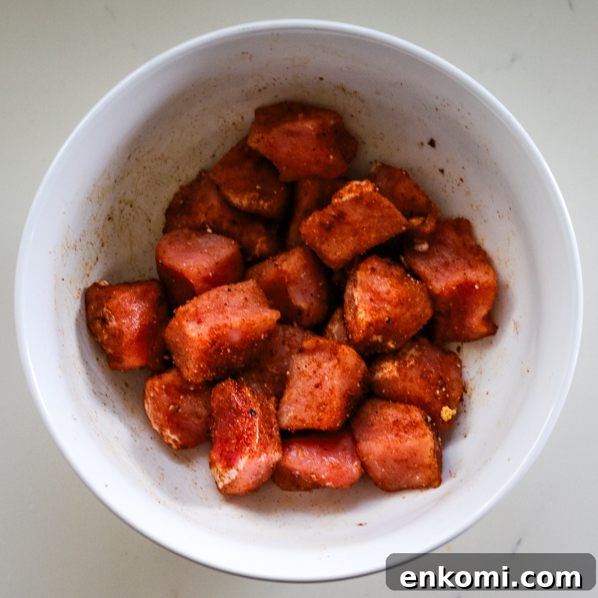 pork bites seasoned in white bowl.