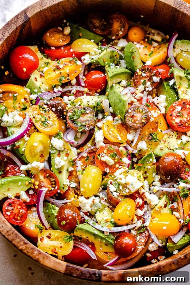 Creamy Avocado and Tomato Salad with Lime Vinaigrette 2 diced avocados, sliced tomatoes, sliced onions, and crumbled cheese in a wooden salad bowl