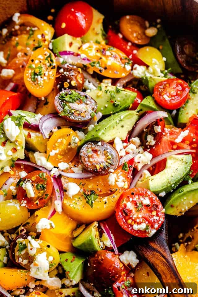 Creamy Avocado and Tomato Salad with Lime Vinaigrette 5 close up top shot of a salad with cherry tomatoes, heirloom tomatoes, avocado, and crumbled bleu cheese