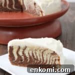 Classic Zebra Cake Recipe: Striped Chocolate and Vanilla Layers 2 slice of Zebra Cake with cake on stand in background