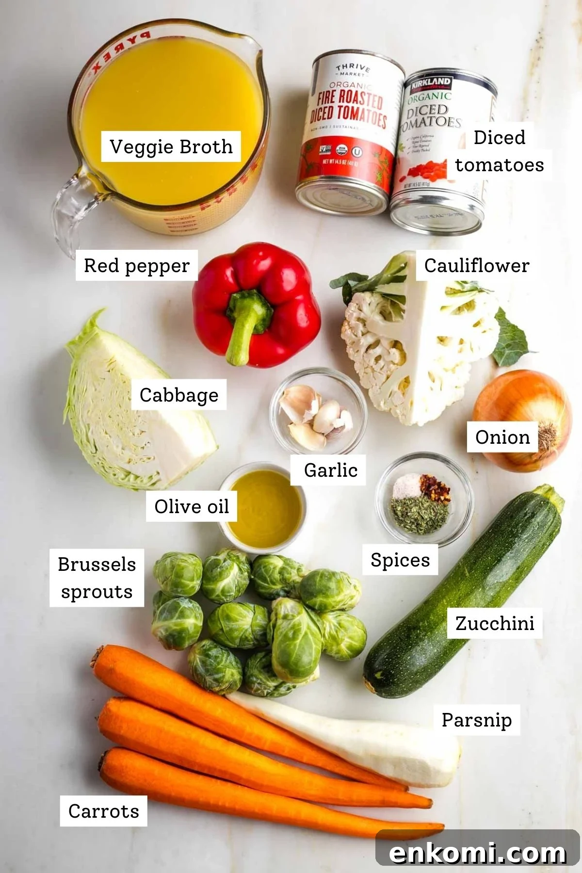 Labeled ingredients for roasted veggie soup: broth, tomatoes, bell pepper, cabbage, cauliflower, carrots, parsnips, zucchini, spices, garlic.