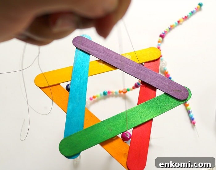child hand beading on string.