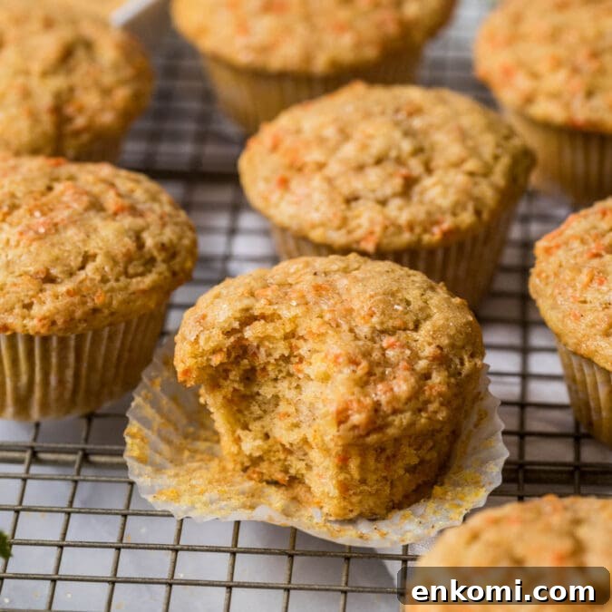 30 Muffin Recipes: Sweet, Savory & Seasonal Ideas 15 Carrot muffins on a cooling rack with the center muffin unwrapped and missing a bite.
