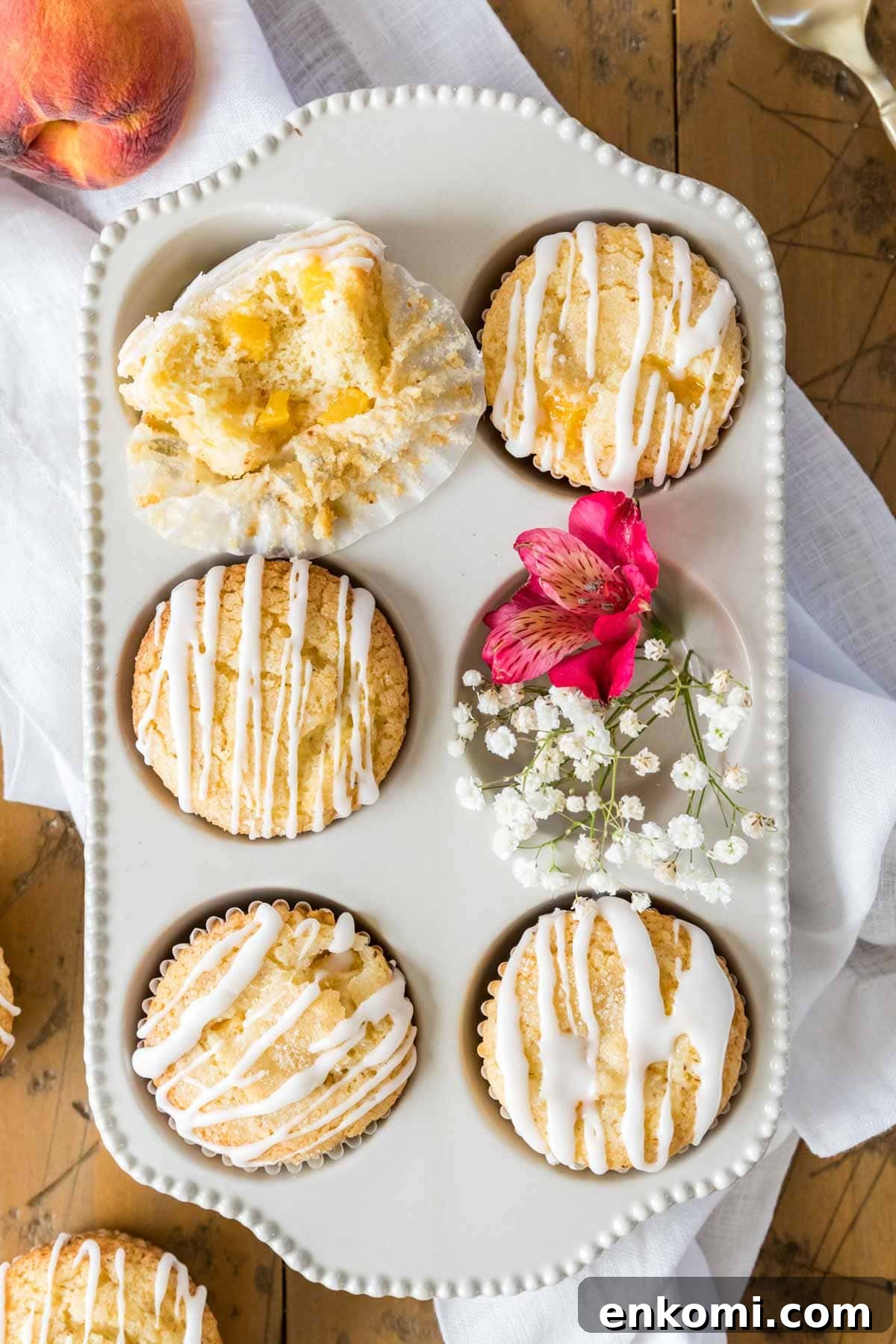 30 Muffin Recipes: Sweet, Savory & Seasonal Ideas 30 Overhead view of a six count muffin tin filled with muffins, with the top left muffin missing a bite.