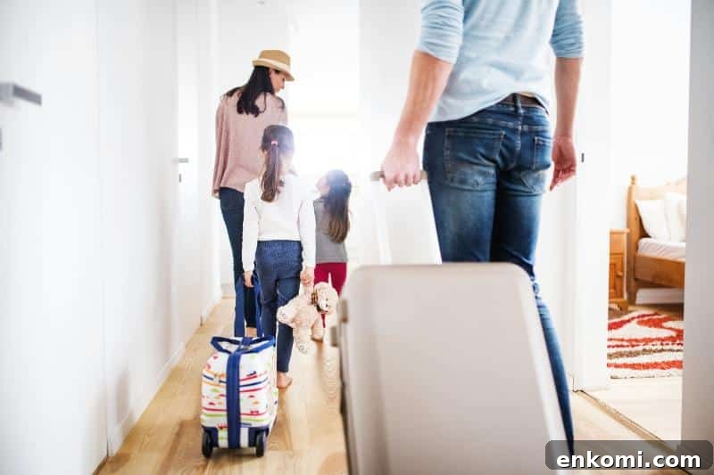 Toddler Travel Clothing Checklist: What to Pack for Trips 2 family of 4 walking down hallway with luggage before a trip