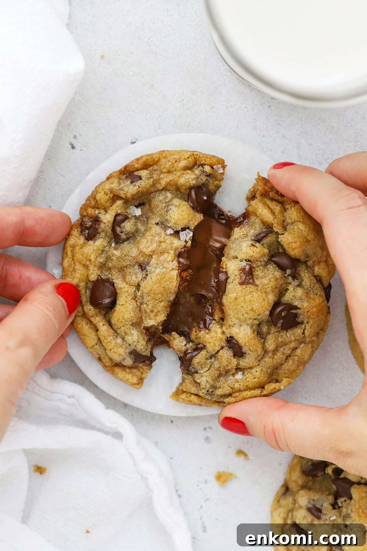 Pulling apart a gluten-free Nutella chocolate chip cookie, revealing the gooey nutella center