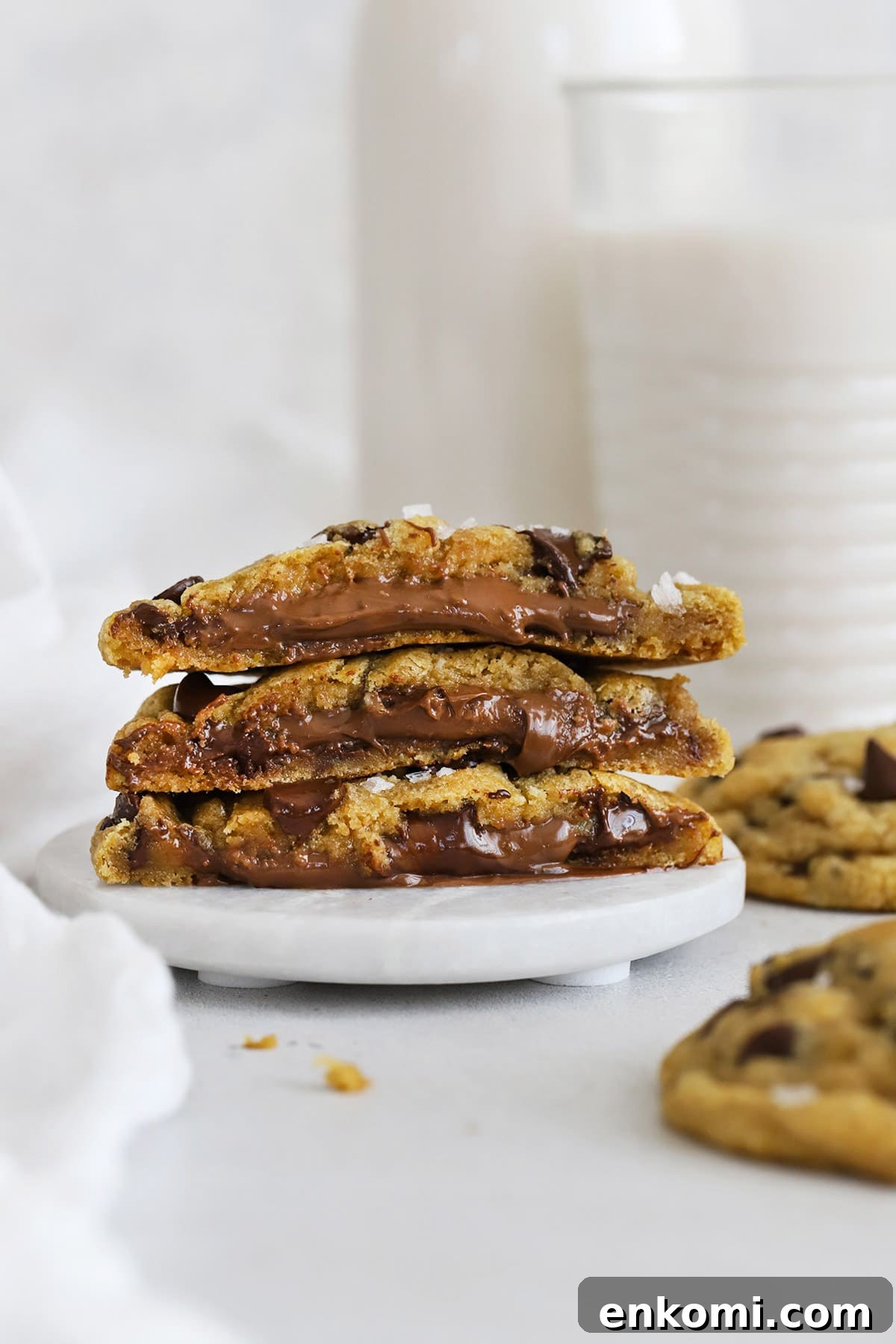 Halved gluten-free Nutella stuffed chocolate chip cookies stacked on top of each other