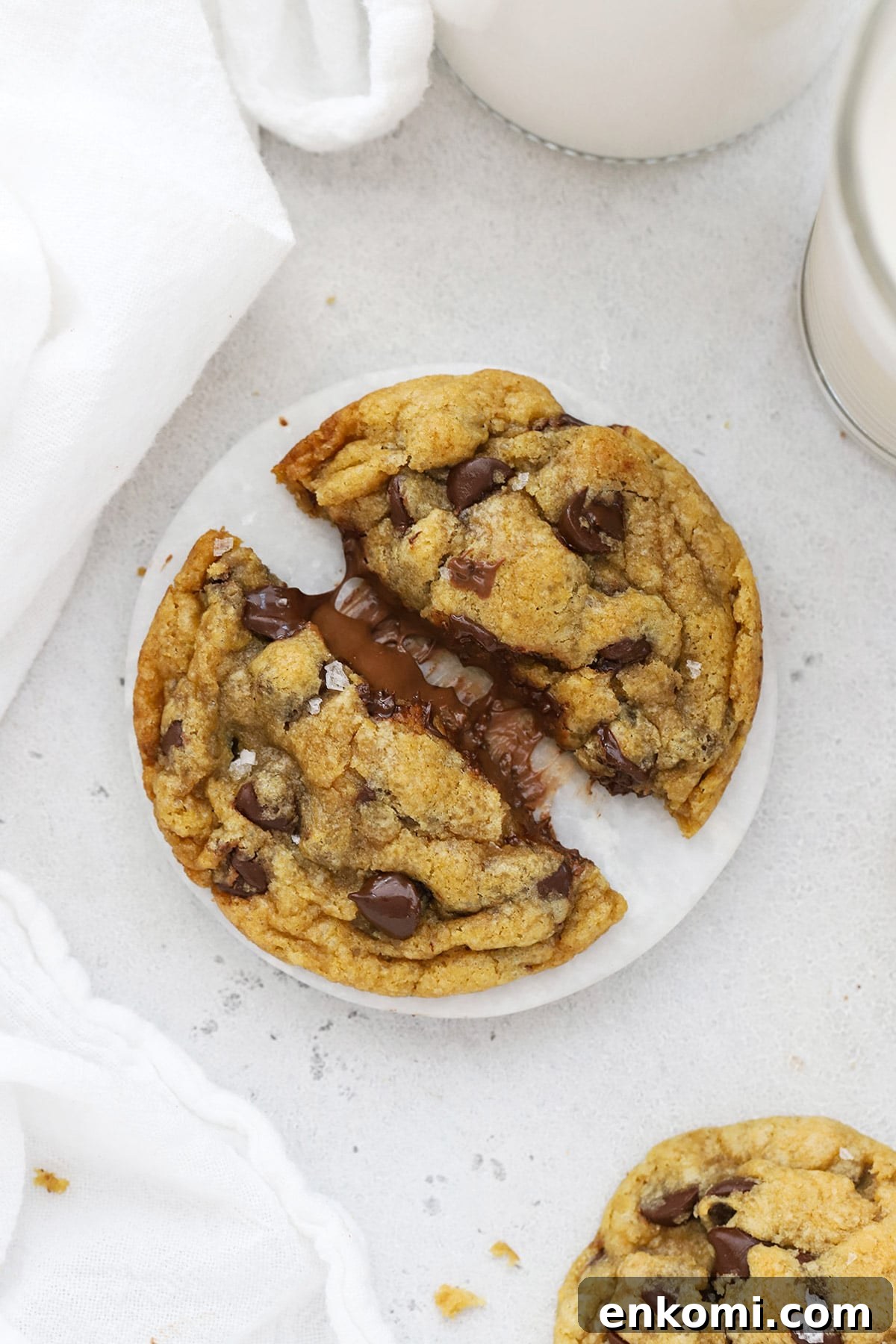 Gluten-free Nutella stuffed chocolate chip cookie being pulled apart to reveal the gooey nutella center